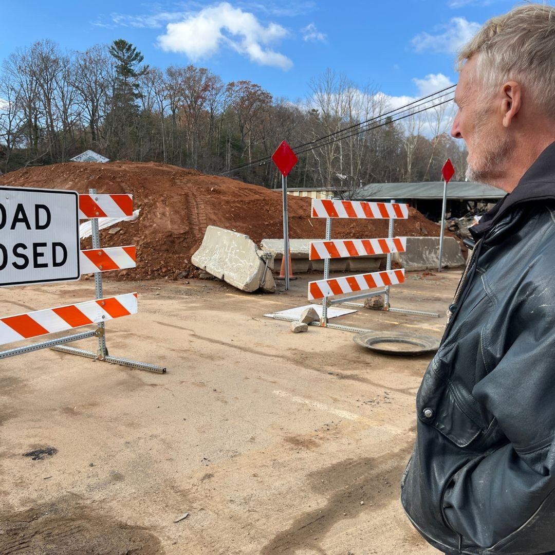 man viewing "road closed" sign