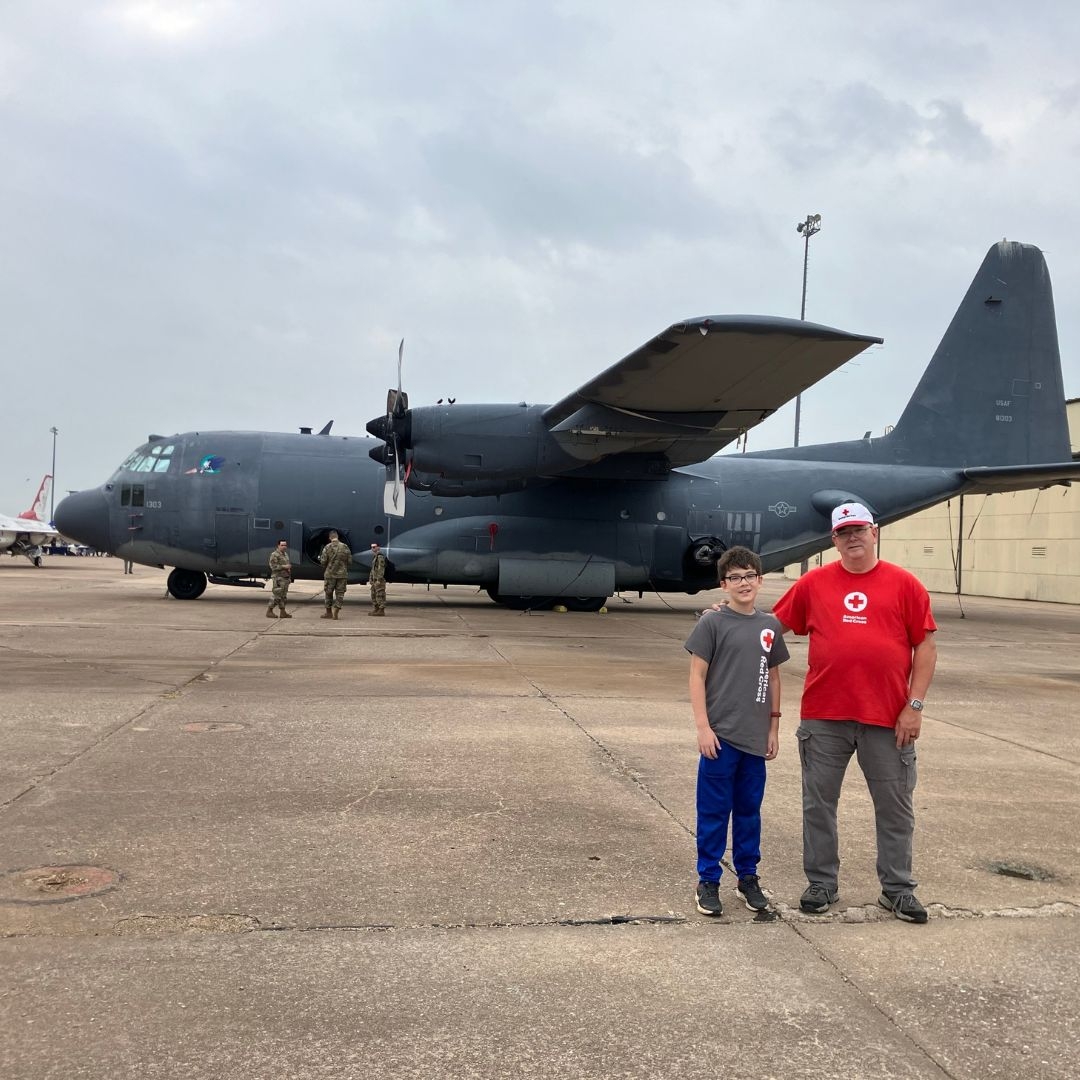 Red Crosser Glenn Parker and his grandson, Junior Red Crosser Korbyn Parker in front of plane