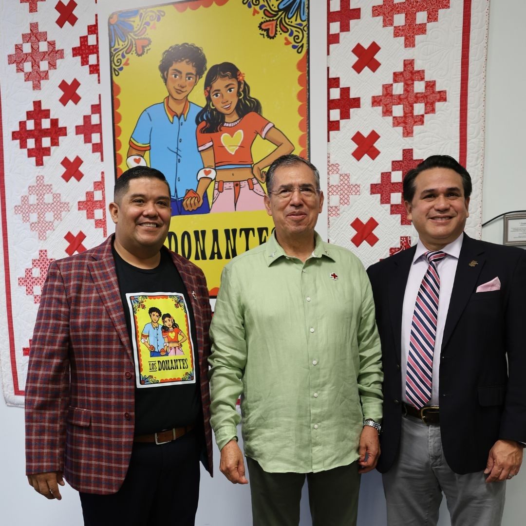 three men standing in front of los donantes sign