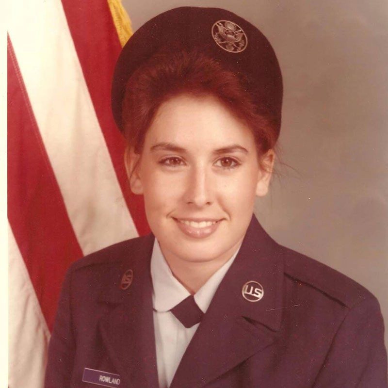 Stephanie Carter in military uniform with american flag next to her.
