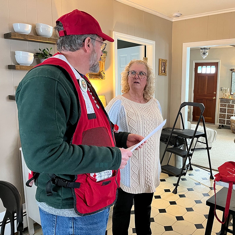 Red Cross volunteer speaking with a local resident in her kitchen.
