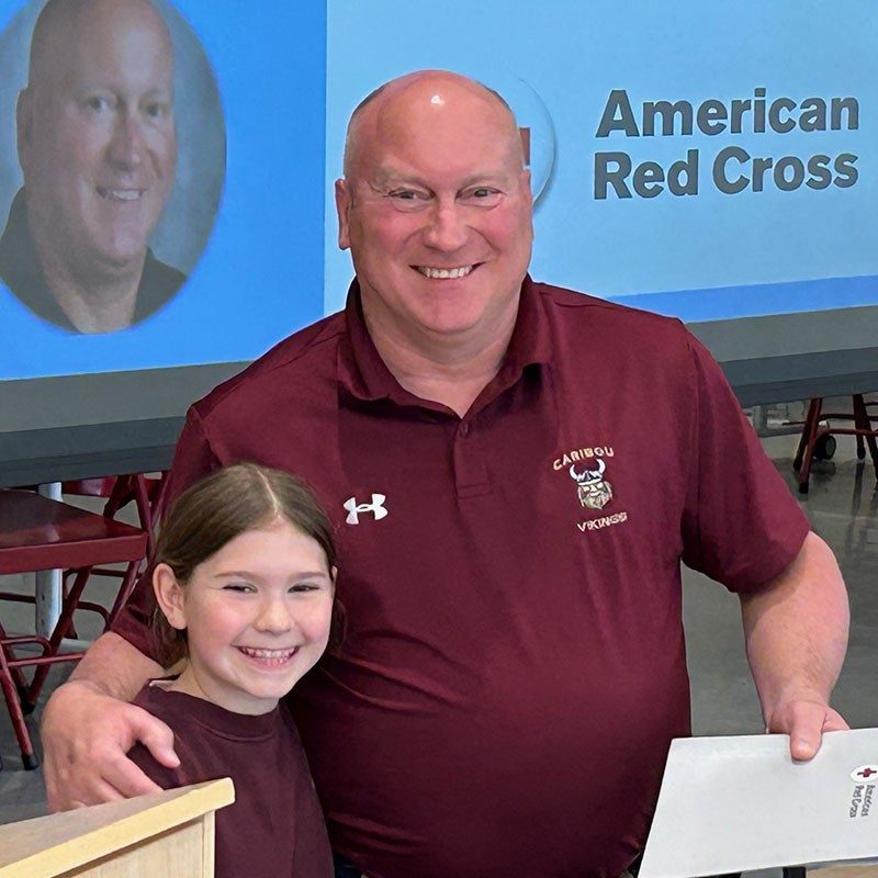 6th-grade Math and science teacher, John Pelletier, with arm around the student he saved at a Red Cross event.