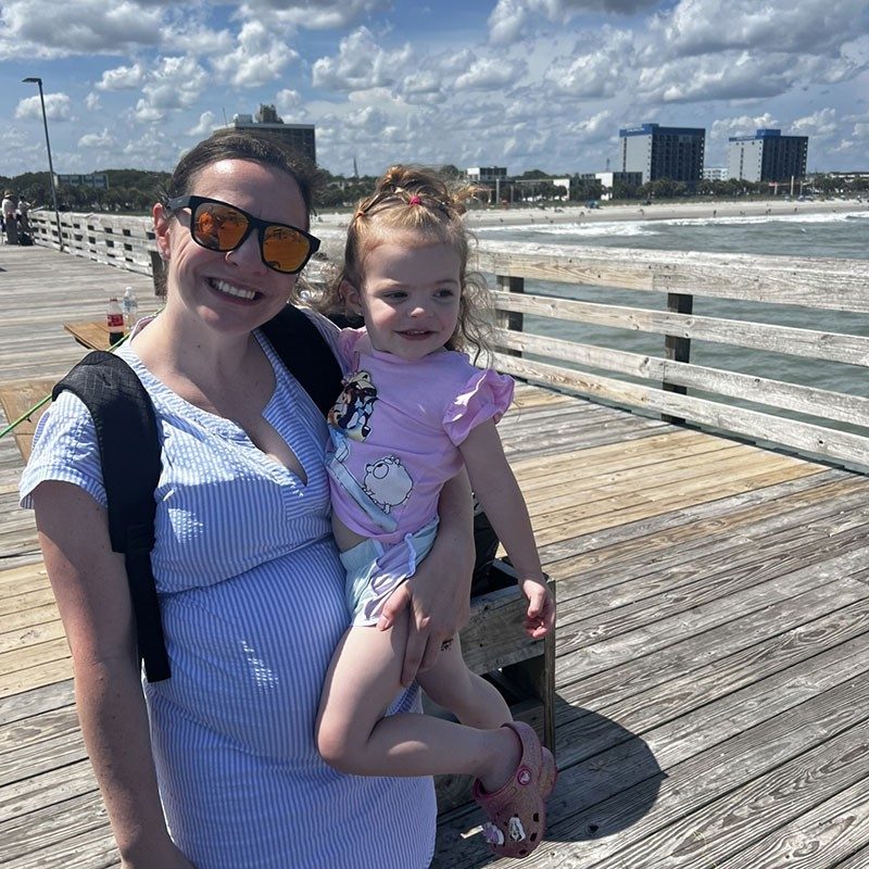Dr. Kristin Gype and her daughter standing on a wooden pier.