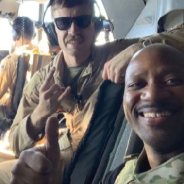 two military members giving a thumbs up in a military aircarft.