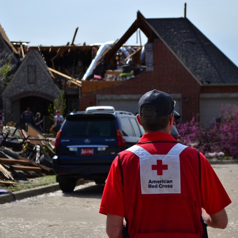 Red Cross volunteer surveying tornado damage. 