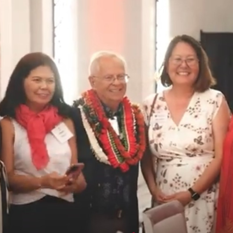 Three Red Cross volunteers posing for a picture wearing leis.