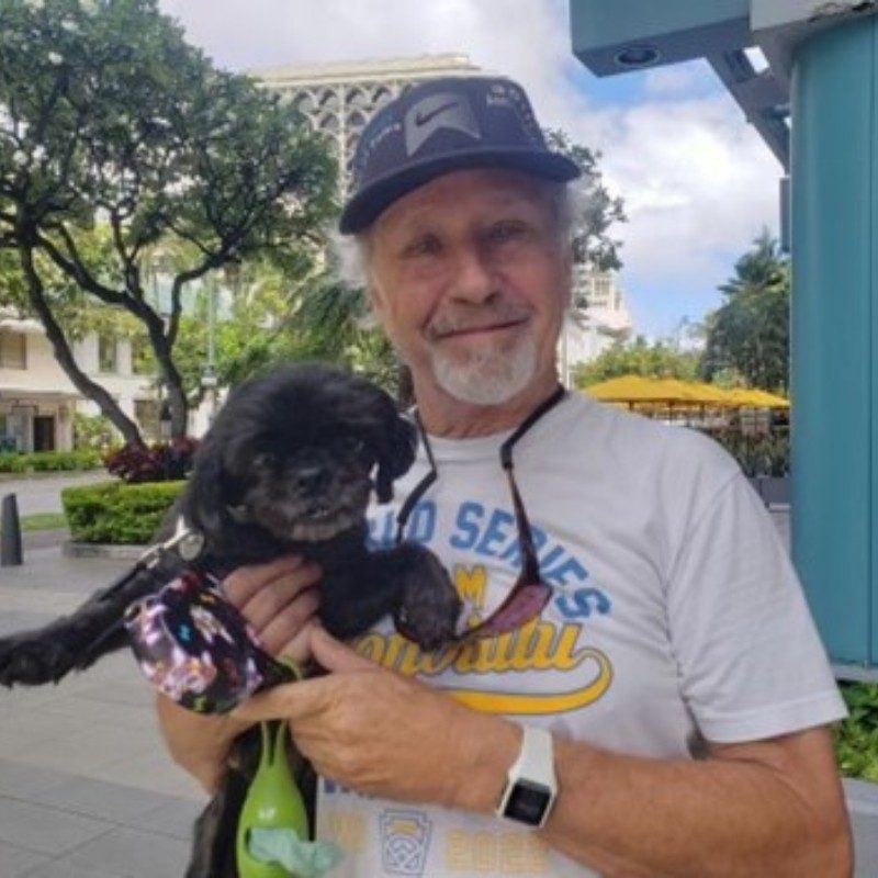Rick smiling while holding Emma the dog.