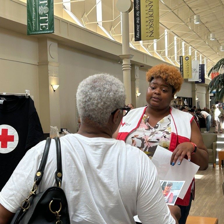 Aja Johnson speaking with resident about Red Cross services.