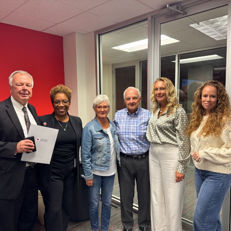 Group of people standing, smiling while posing for a picture.