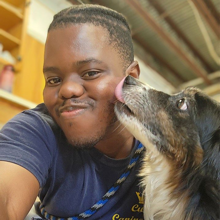 dog licking the side of Julius Nelson's face.
