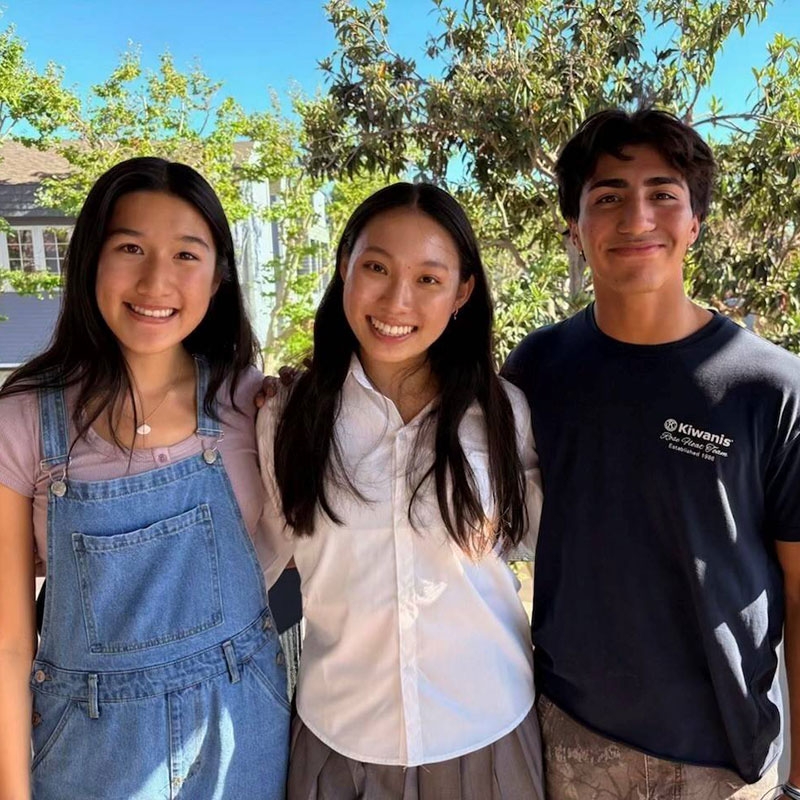 three Youth Volunteers smile for picture.