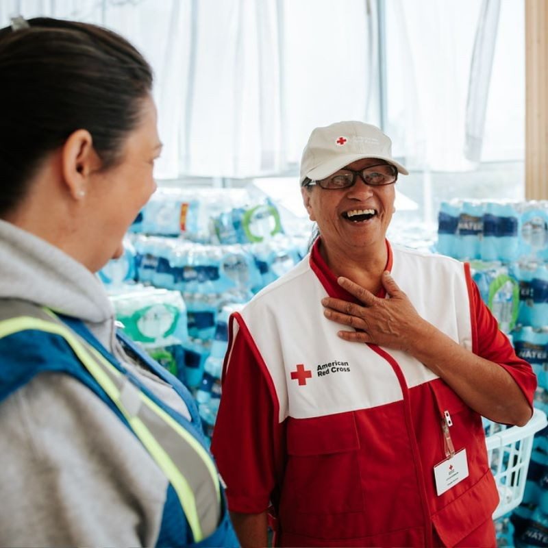 Red Cross volunteer smiling at Walmart worker.