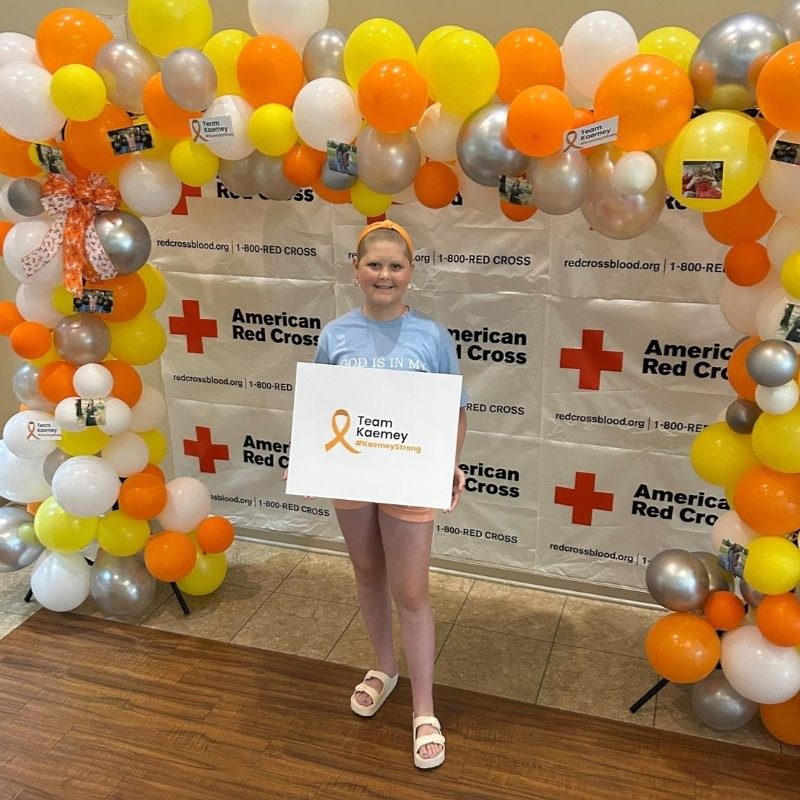 Kaemey Young smiling holiding a sign that says #TeamKaemey.