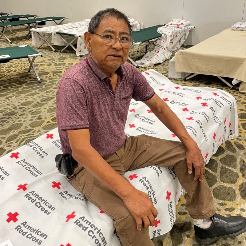Santana Garcia stting on a cot in a Red Cross shelther. 