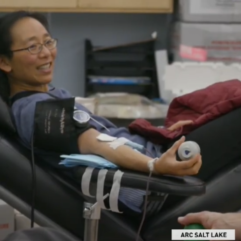 Person laying on chair donating blood.