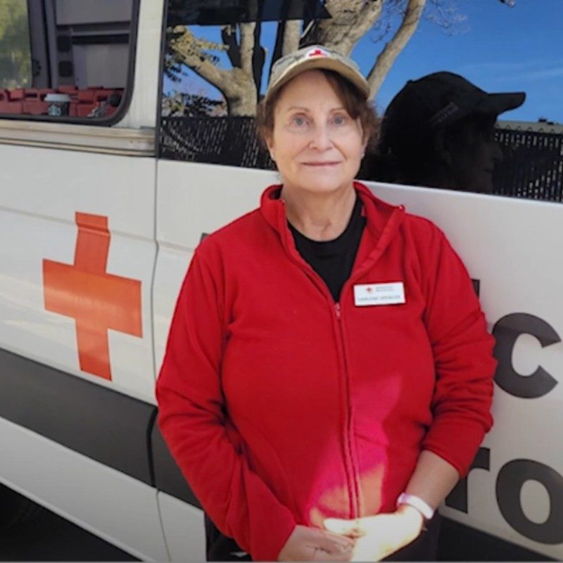 Darlene standing in front of a Red Cross Emergency Response Vehicle.