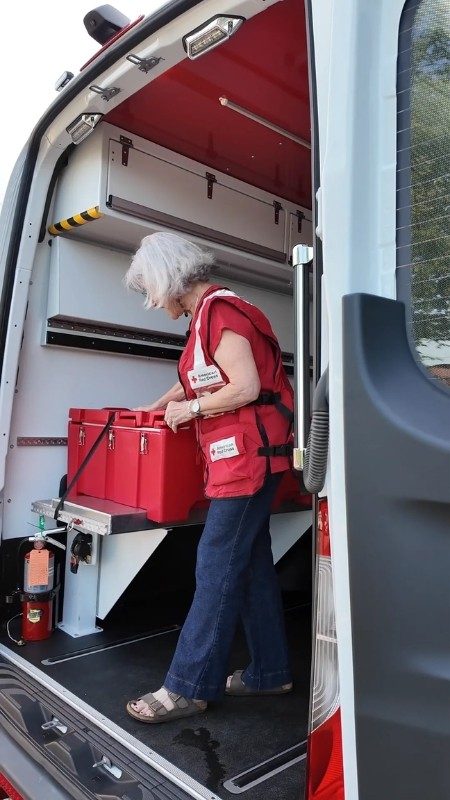  Red Cross volunteers removing supplies from truck.