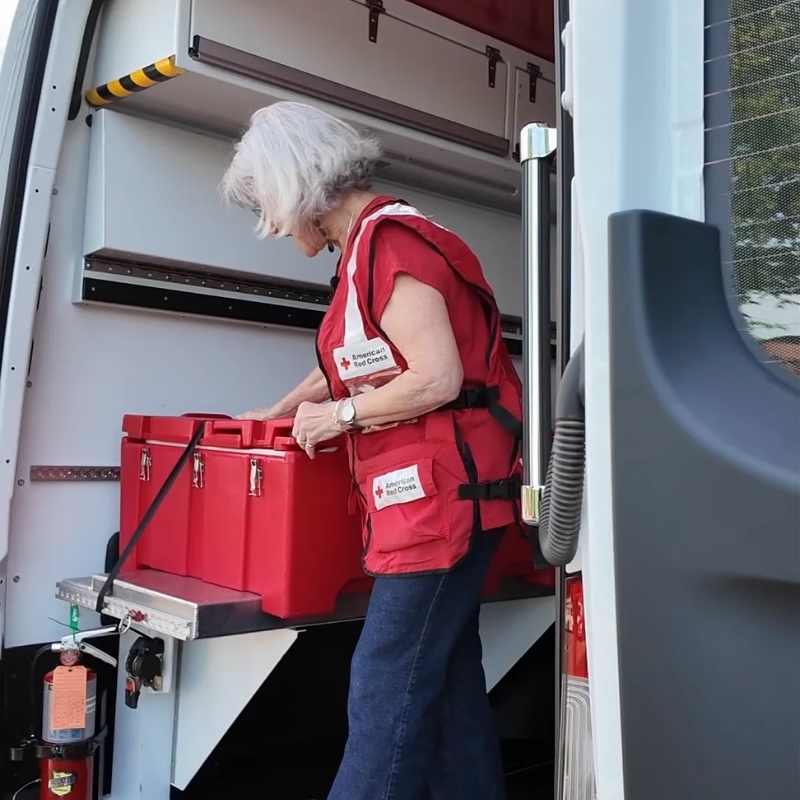  Red Cross volunteers removing supplies from truck.