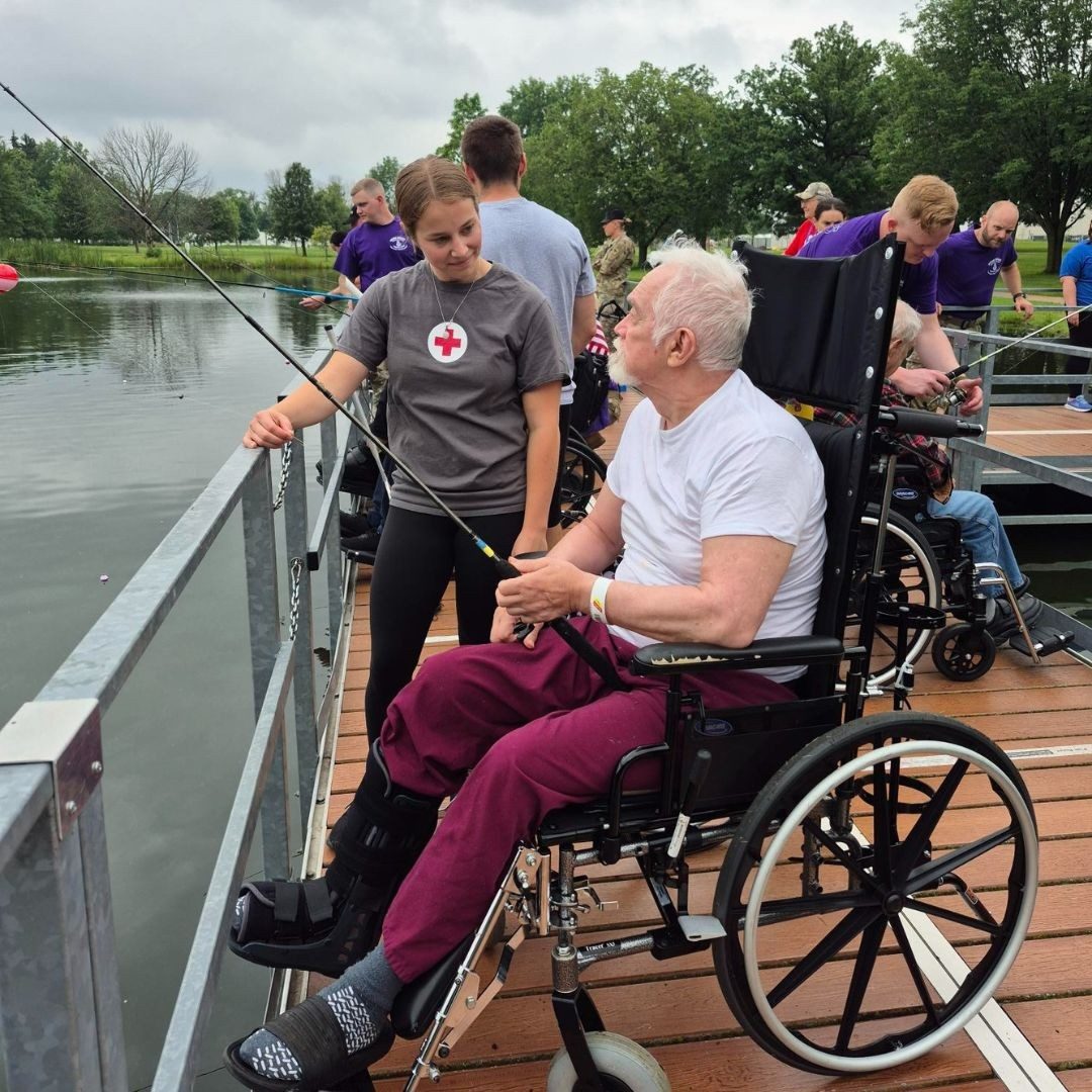 veteran with volunteer looking over lake from bridge.