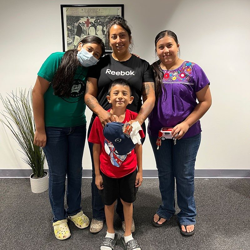 a mother an her three children take a group picture inside a Red Cross building.