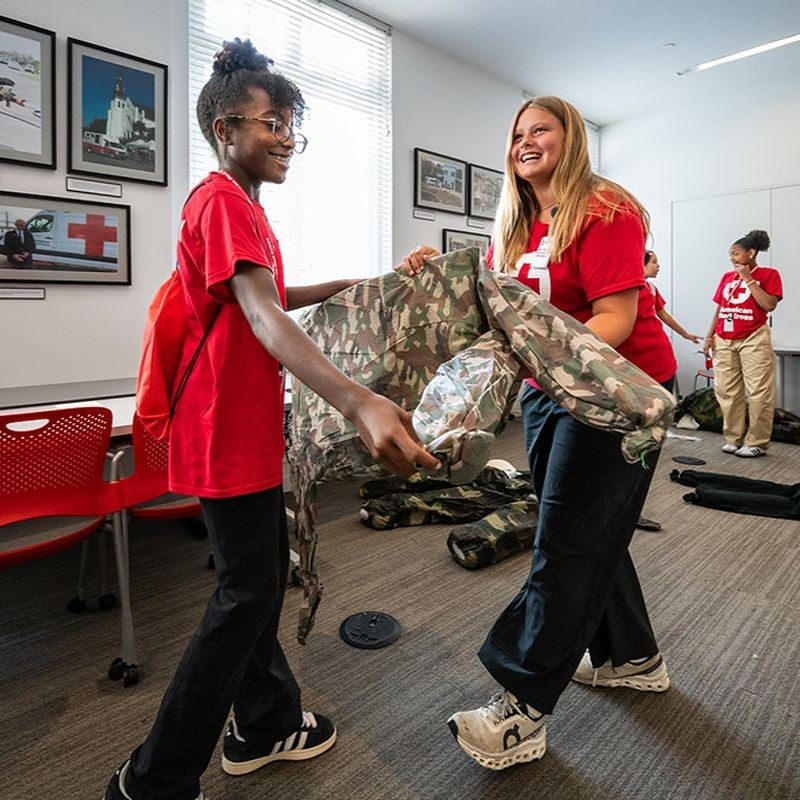 Two teens helping to carry items.