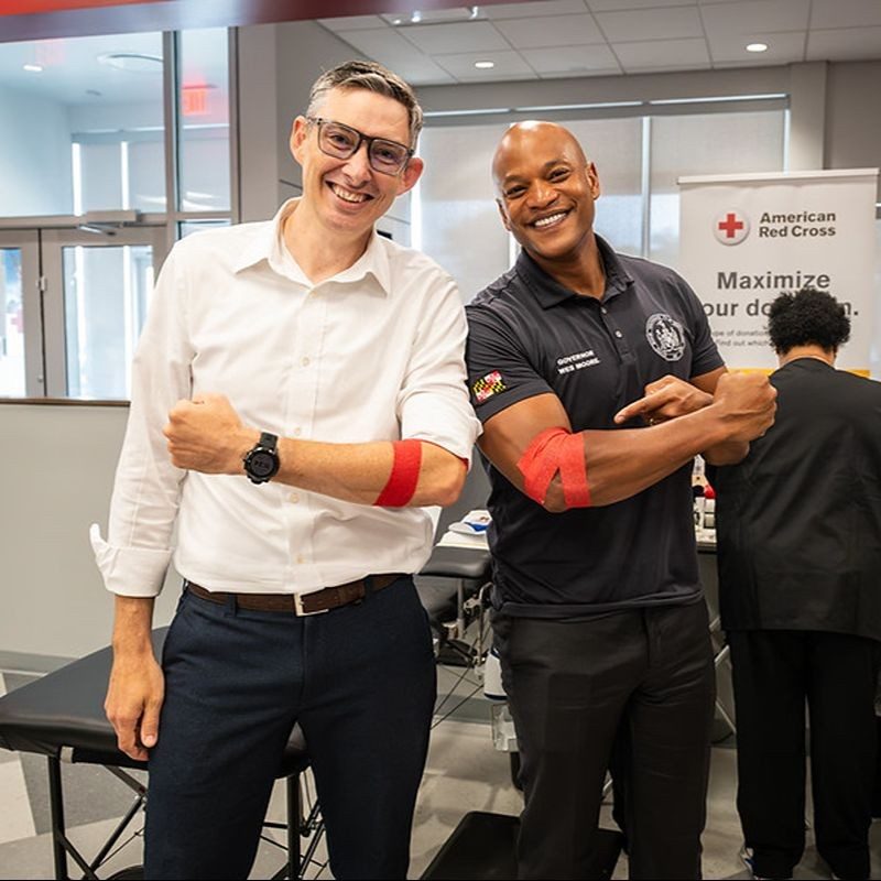 Maryland Gov. Wes Moore donating blood with another person.