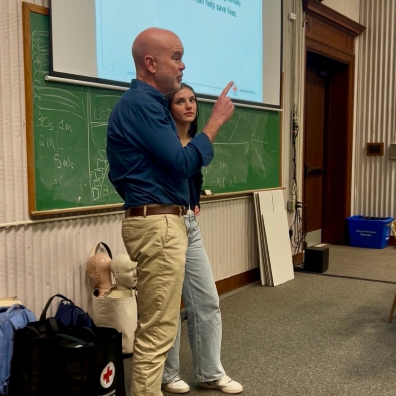 Peter teaching CPR to a class with his daughter.