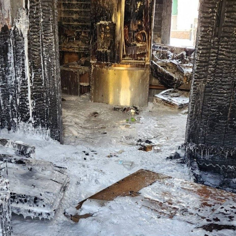 Burnt home filled with ash and snow.