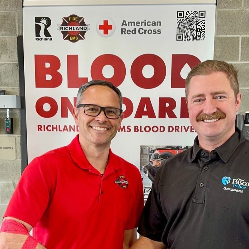 Two Red Cross blood donors shaking hands.