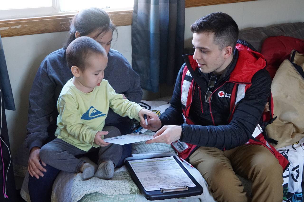 Red Cross volunteer speaking iwth a mom and her son about home fire safety