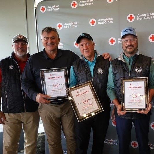 men holding awards at golf tournament
