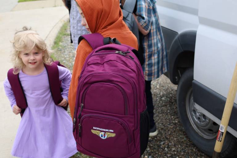 Two young children model their backpacks from Backpack4Kids