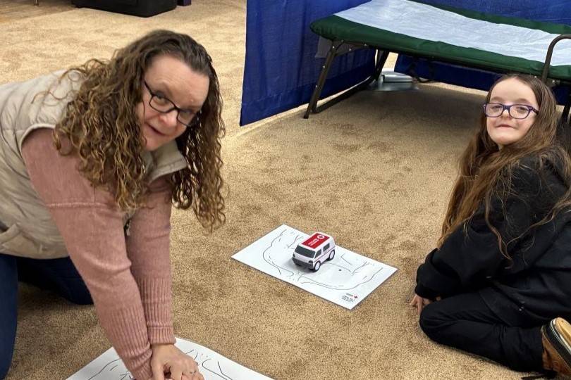 Woman and young girl practice chest compressions