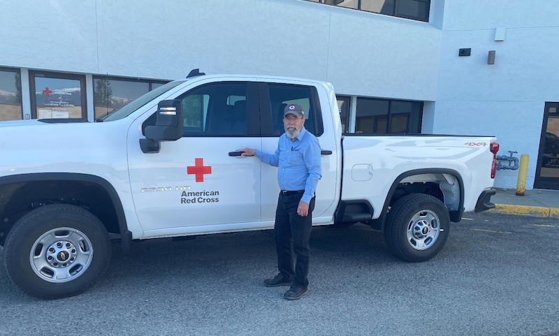 Red Cross male employee standing in front of a Chevy Silverado pickup truck