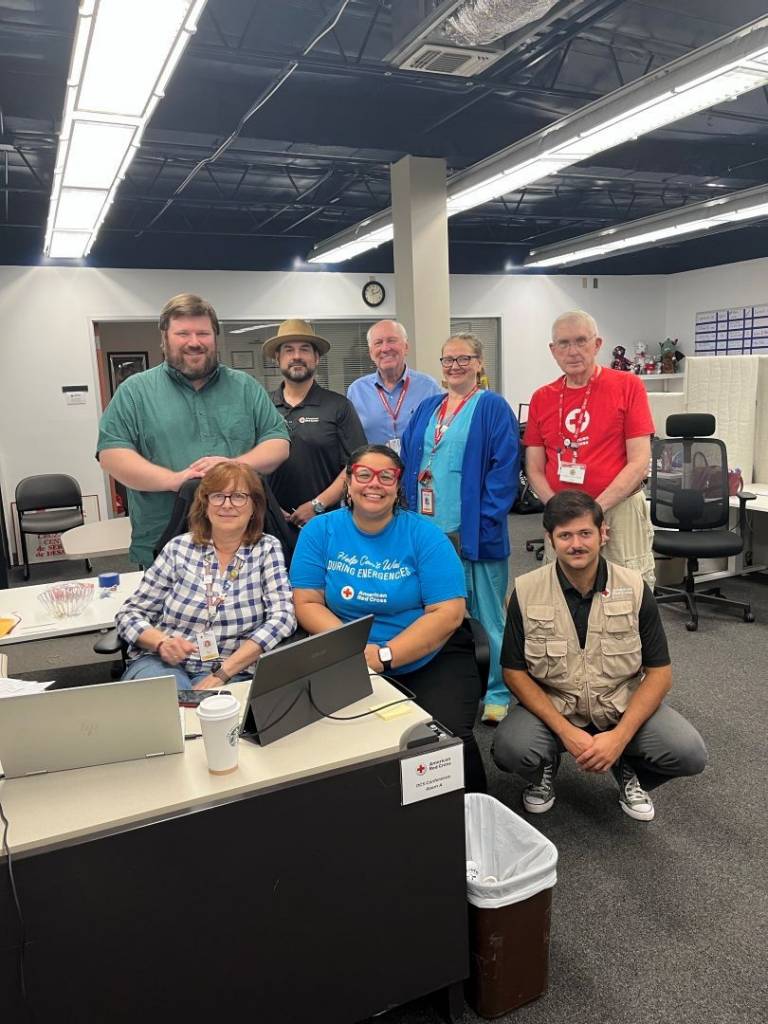 Group of Red Cross volunteers stand in office space