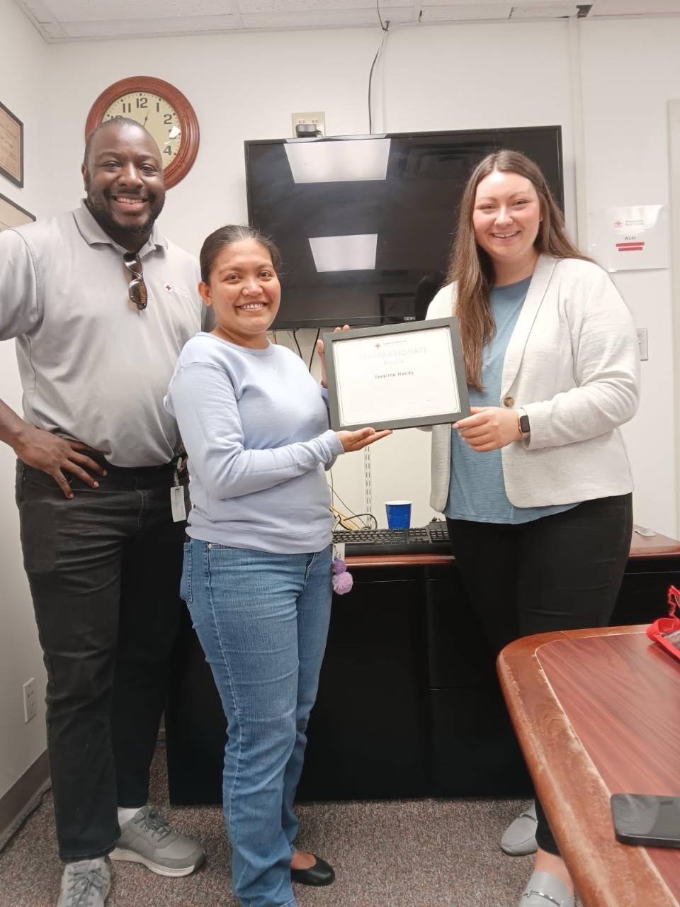 man stands beside two women holding award