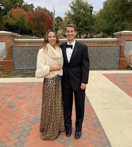 Couple in formal attire stands outdoors