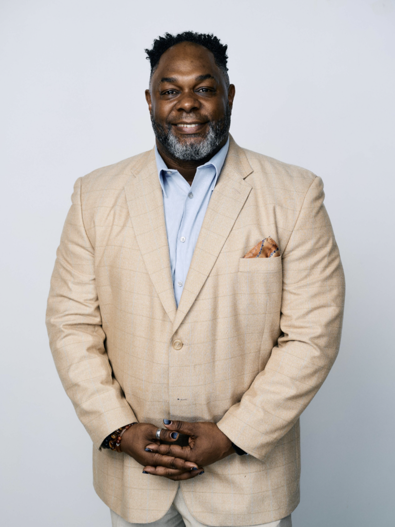 Headshot of man in tan suit