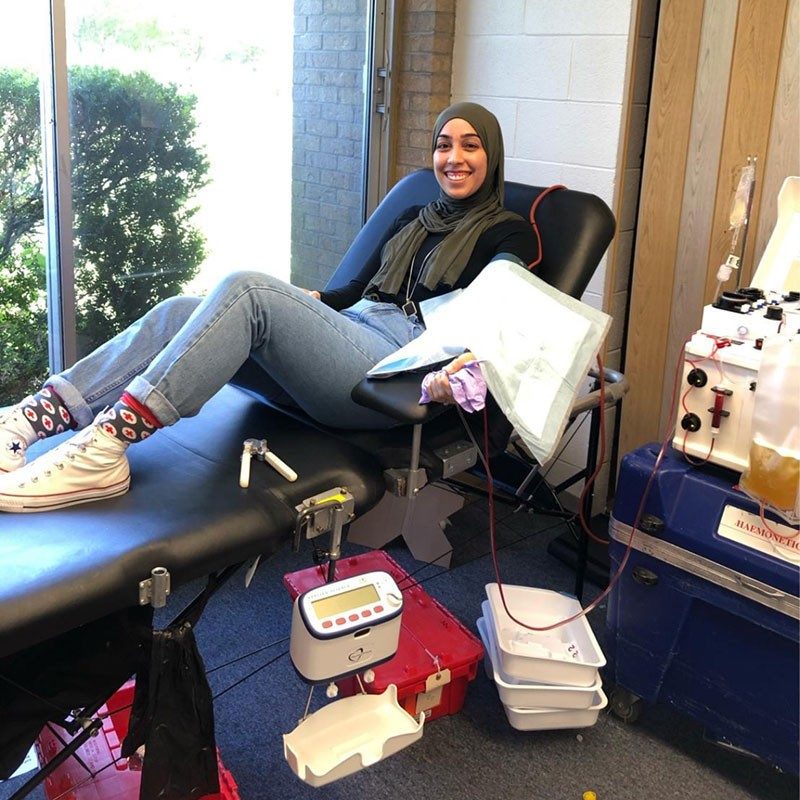 Reihaneh Hajibeigi sitting in chair while donating blood.