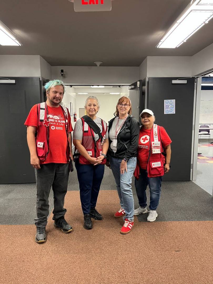Four Red Cross volunteers stand in a row