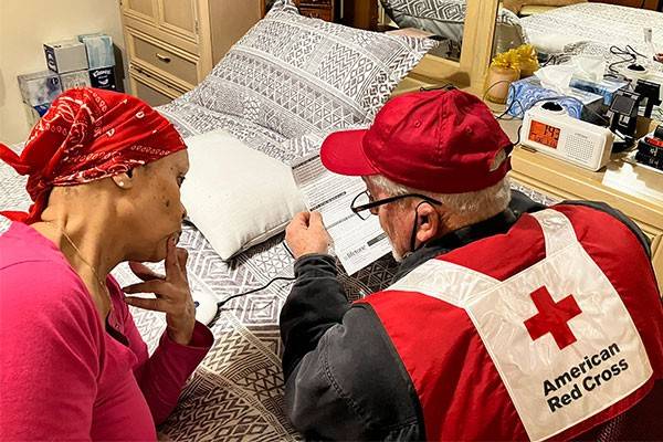 Red Cross volunteer speaking with resident