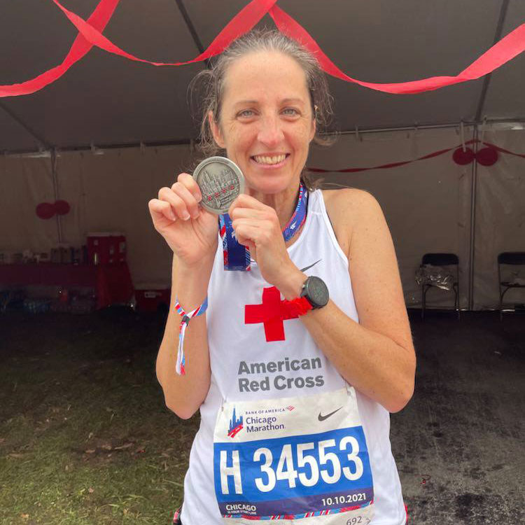 Marathon runner holding medal and smiling