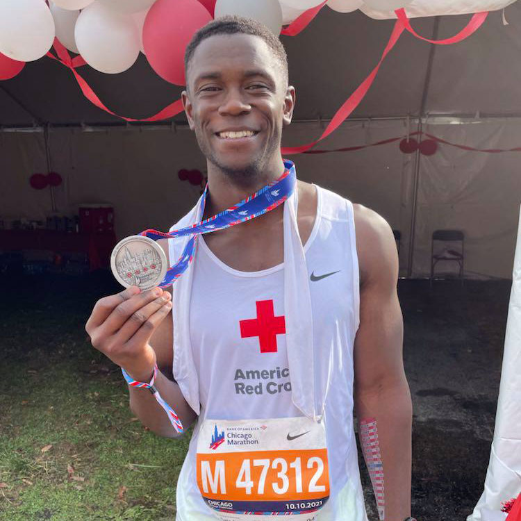 Marathon runner holding medal and smiling