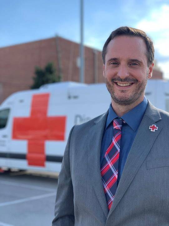 Brice Johnson in suit next to Red Cross van