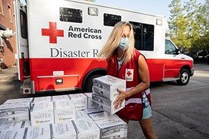 A Red Cross volunteer brings relief supplies after a hurricane