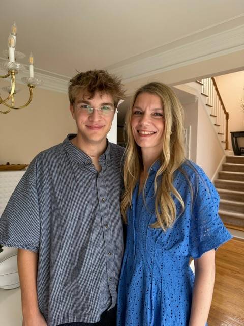 Woman stands with her son inside home