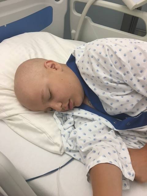 Young boy lays in hospital bed