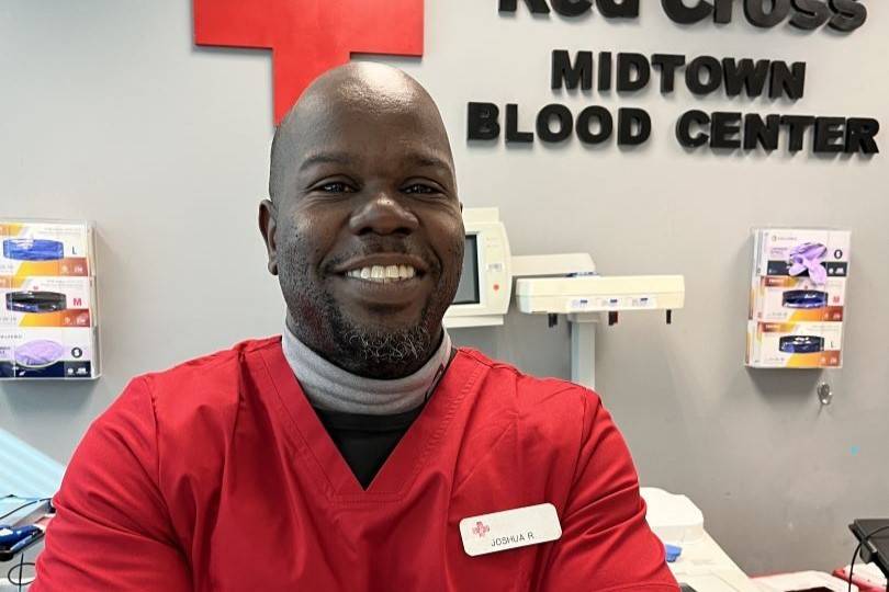 Man smiles while standing in blood donation center