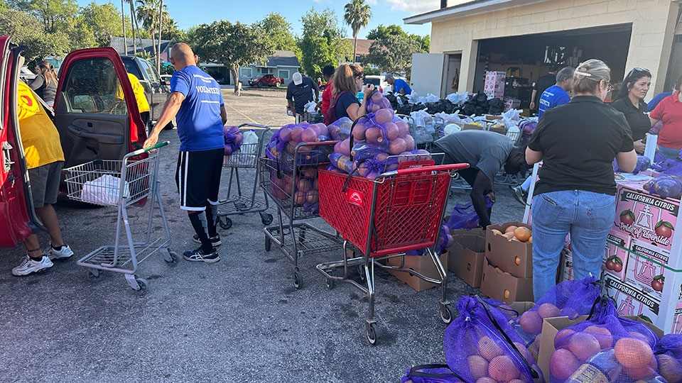 people with carts loading food outside a local food pantry.