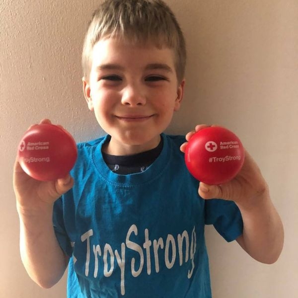 troy ross smiling holding red cross balls